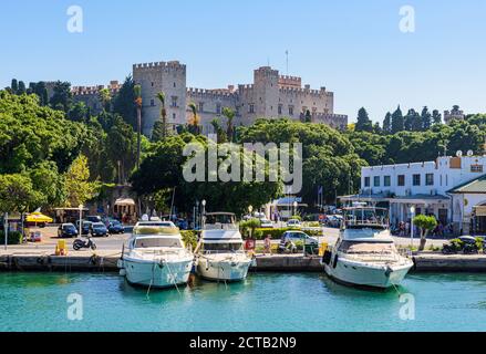 Boote, die im Mandraki Hafen unter dem alten mittelalterlichen Palast der Großmeister, Rhodos Stadt, Rhodos Insel, Griechenland, festgemacht sind Stockfoto