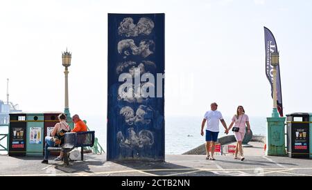 Brighton UK 22. September 2020 - Besucher genießen heute einen weiteren heißen Sonnentag an der Kiss Wall Skulptur von Bruce Williams an der Strandpromenade von Brighton, aber das Wetter ist für viel kühlere Bedingungen ab morgen vorhergesagt : Credit Simon Dack / Alamy Live News Stockfoto