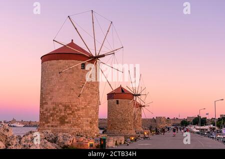 Sonnenuntergang über den Windmühlen im Mandraki Hafen, Rhodos Stadt, Rhodos Insel, Griechenland Stockfoto
