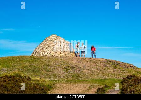 Wanderer auf der Gedenkgipfel Cairn auf Dunkery Beacon - der höchste Punkt in Somerset und Exmoor National Park (1.705ft), England, Großbritannien Stockfoto