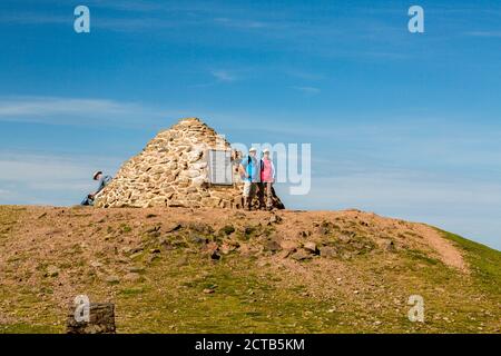 Wanderer auf der Gedenkgipfel Cairn auf Dunkery Beacon - der höchste Punkt in Somerset und Exmoor National Park (1.705ft), England, Großbritannien Stockfoto