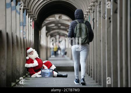 REDAKTIONELLE VERWENDUNG NUR EIN Mann, der als Weihnachtsmann verkleidet ist, bittet Passanten in Newcastle, ihn rechtzeitig zum Start des Weihnachts-Fernsehsenders Sony Movies aufzuwecken, der am 24. September live geht. Stockfoto