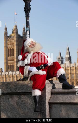 REDAKTIONELLE VERWENDUNG NUR EIN Mann, der als Weihnachtsmann verkleidet ist, bittet Passanten in London, ihn rechtzeitig zur Vorstellung des Weihnachtsfernsehens von Sony Movies aufzuwecken, der am 24. September live geht. Stockfoto