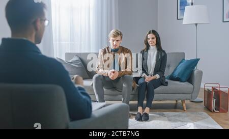 Junges Paar auf einer Beratungssitzung mit Psychotherapeut. Rückansicht des Therapeuten: Junge Leute sitzen auf der Analyst Couch, diskutieren über psychologische Stockfoto