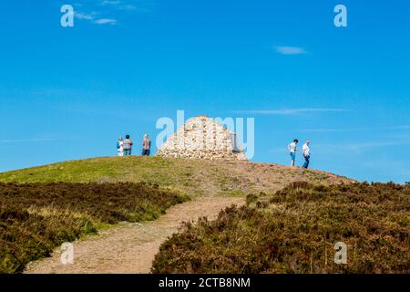 Wanderer auf der Gedenkgipfel Cairn auf Dunkery Beacon - der höchste Punkt in Somerset und Exmoor National Park (1.705ft), England, Großbritannien Stockfoto