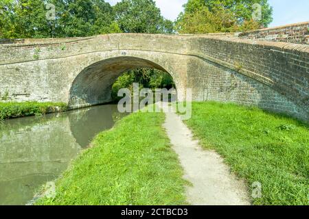 Brücke 47 auf dem Grand Union Canal in der Nähe von Blisworth in Northamptonshire mit Reflexionen unter der Brücke und im Wasser. Stockfoto