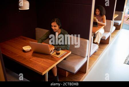 Geschäftsfrauen Arbeiten In Sozial Distanzierten Kabinen Im Modernen Büro Während Gesundheitliche Pandemie Stockfoto