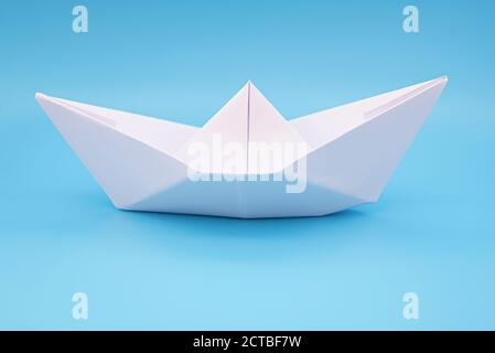 Papier Schiff Origami auf blauem Hintergrund Oberfläche als Wasser Stockfoto