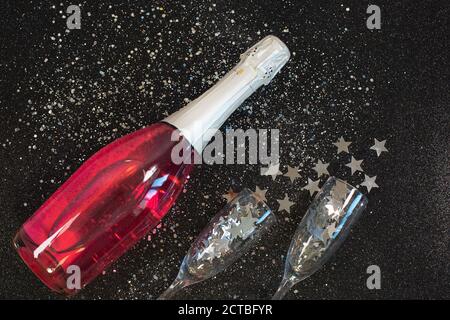 Zwei Sektgläser mit Konfetti auf schwarzem Hintergrund. Stockfoto
