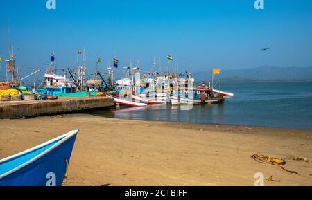 Hafen für kleine Fischerschiffe in Gokarna, Karnataka, Indien.nicht erkennbare Personen in der Ferne auf dem Boot Stockfoto