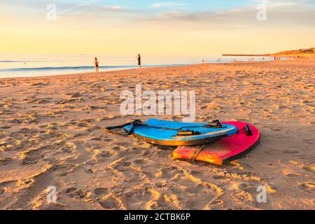 Schwimmen Bodyboards auf dem Sand bei Sonnenuntergang, Christies Beach, South Australia Stockfoto