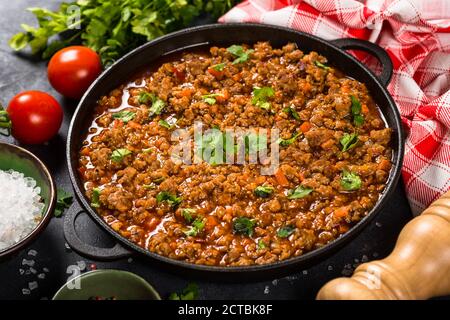 Bolognese steht in Eisenplatte am schwarzen Tisch. Stockfoto