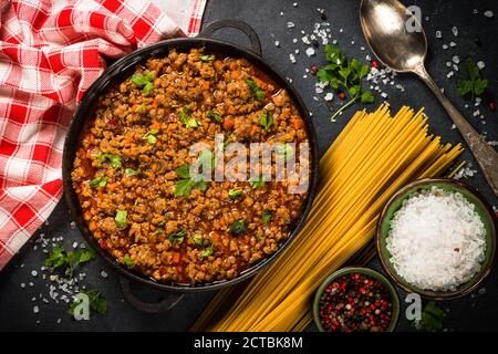 Bolognese steht in Eisenplatte am schwarzen Tisch. Stockfoto