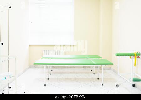 Das Krankenhaus. 2 Betten in einem privaten Zimmer auf der Krankenstation. Heller Raum mit beigefarbenen Wänden und Jalousien an den Fenstern. Ausrüstung für einen medizinischen Tropfer. Stockfoto