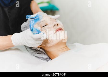 Frau mit stimulierenden Gesichtsbehandlung in der professionellen Klinik. Stockfoto