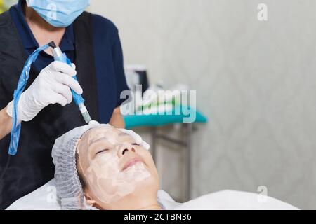 Frau mit stimulierenden Gesichtsbehandlung in der professionellen Klinik. Stockfoto