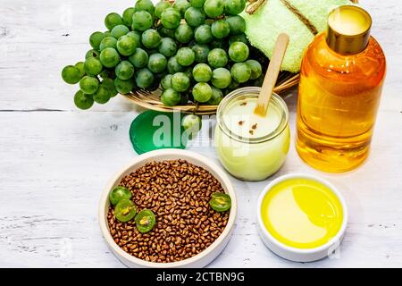 Natürliche Spa-Accessoires und grüne Trauben. Frische Zutaten für eine gesunde und komfortable Selbstpflege. Weiße Holzbretter Hintergrund, Nahaufnahme Stockfoto