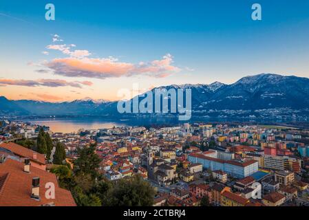 Panoramablick über die Stadt Locarno und den Lago Maggiore in der Dämmerung im Tessin, Schweiz. Stockfoto