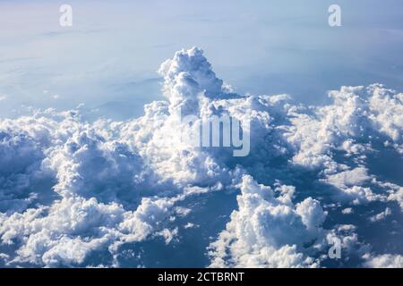 Cumulus Gewitterwolken in blauem Himmel. Wunderschöne Frühlingslandschaft mit wolkigen Skyline, Luftbild vom fliegenden Flugzeugfenster Stockfoto