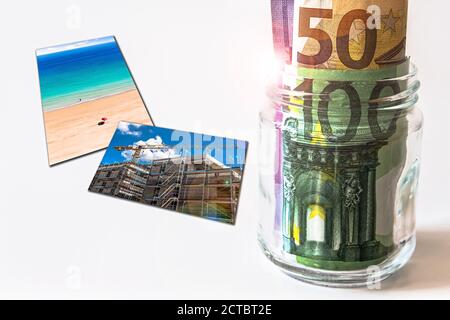 Glasglas gefüllt mit Euro Banknoten neben Fotos von Einige Ziele Stockfoto