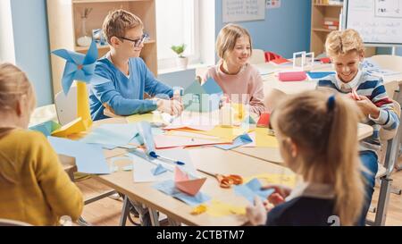 Grundschule Kunst Handwerk Klasse: Diverse Gruppe von intelligenten Kindern Spaß haben auf einem Handwerk Projekt, mit bunten Papier, Schere und Kleber Stockfoto