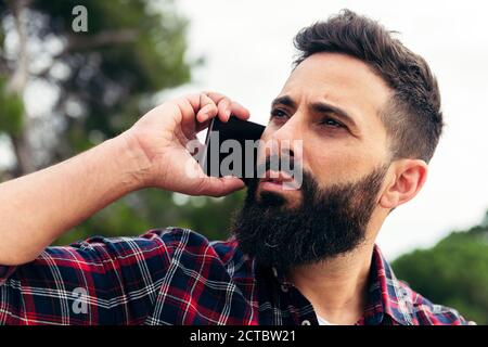 Porträt eines schönen bärtigen Mann ruft auf seinem Handy, Konzept der Freiheit und Technologie Stockfoto