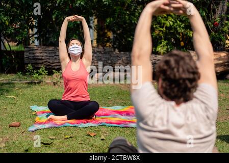 Frau trägt Maske auf einem Fitness-Kurs im Freien Stockfoto