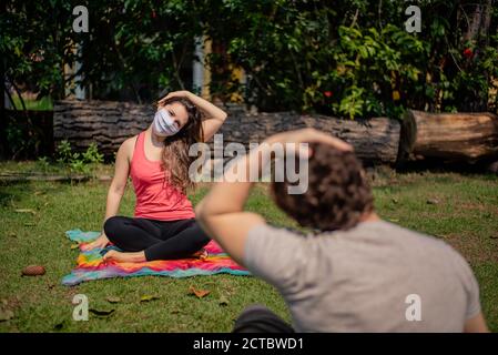 Frau trägt Maske auf einem Fitness-Kurs im Freien Stockfoto