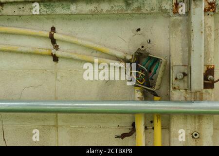 Nahaufnahme des nicht abgedeckten elektrischen Anschlusskastens, in dem die Kabel im Inneren des Kastens mit Isolierband verbunden sind Stockfoto