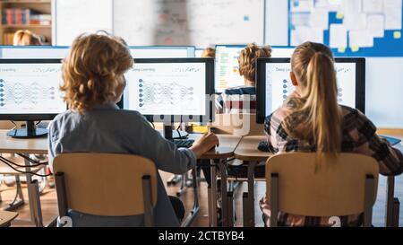 Grundschule Wissenschaft Klassenzimmer: Intelligente kleine Schüler, die auf Personal Computers arbeiten lernen Programmiersprache für Software-Codierung Stockfoto