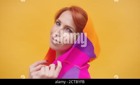 Modische mittleren Alters rote Haare Frau mit bunten Hoodie isoliert auf gelbem Hintergrund. Hochwertige Fotos Stockfoto