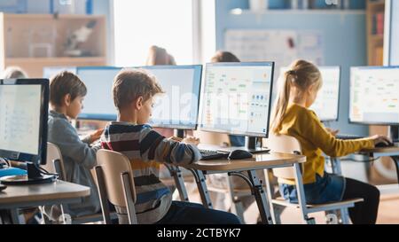 Grundschule Informatik Klassenzimmer: Intelligente kleine Schüler arbeiten an Personal Computers, lernen Programmiersprache für Software-Codierung Stockfoto