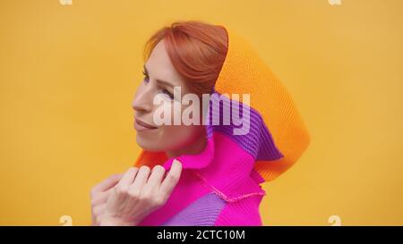 Modische mittleren Alters rote Haare Frau mit bunten Hoodie isoliert auf gelbem Hintergrund. Hochwertige Fotos Stockfoto