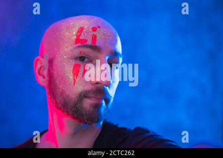 Porträt von gemalten Glatzenkopf Mann in fluoreszierendem Pulver und Farbe. Farbenfrohe, interessante und ungewöhnliche Aufnahmen. Stockfoto