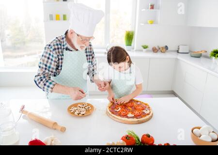 Porträt seines er sie sie fokussierte grauhaarige Enkelkind Teaching Koch hausgemachte Gemüse vegetarische Pizza Pilz Workshop Unterstützung in Leicht Stockfoto