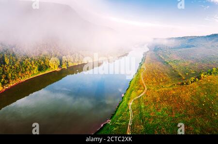 Flug durch majestätischen nebligen Fluss und üppig grünen Wald bei Sonnenaufgang. Landschaftsfotografie. Dnister, Ukraine, Europa Stockfoto