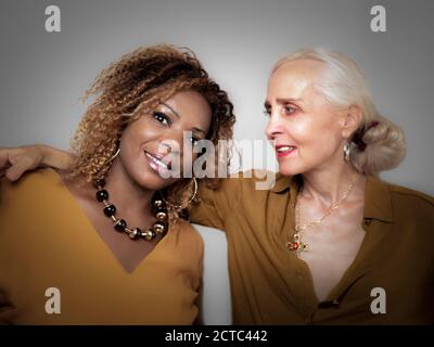 Horizontales Porträt einer weißen Frau, die hält und anschaut Ihre schwarze Freundin Stockfoto