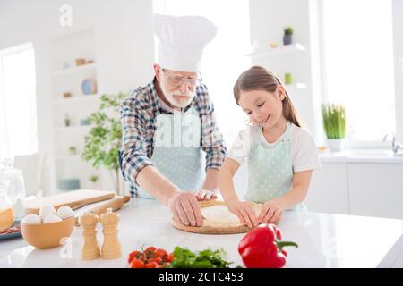 Foto von kleinen Mädchen Enkelin verbringen Zeit mit im Alter Koch Opa bilden Teig für Familie Pizza Rezept Backen zusammen kochen Wochenendhaus Stockfoto