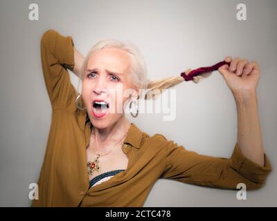 Horizontales Porträt einer eleganten schönen Frau schreien beim Loslassen Ihr Haar Stockfoto