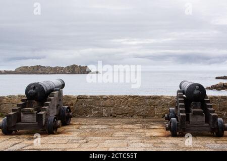 Kanonen mit Blick auf das Meer auf der 18th Centaury Kanonenplattform von Cromwell's Castle, Tresco, Isles of Scilly Stockfoto