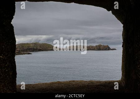 Ein Blick auf Shipman's Head auf Bryher gesehen, obwohl ein Schlupfloch in Cromwell's Castle auf Tresco, Isles of Scilly Stockfoto