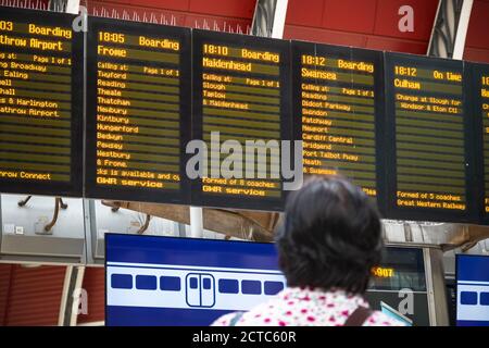 Rückansicht eines Passagiers mit Blick auf den Zugfahrplan bei Bahnhof London Paddington Stockfoto