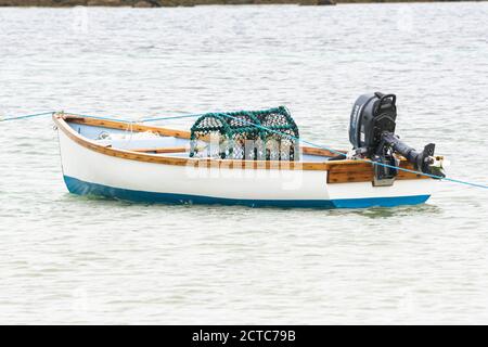Ein Hummertopf in einem kleinen Holzboot vor Anker von Green Porth, Tresco, Isles of Scilly Stockfoto
