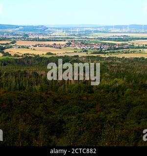 Blick über den dichten grünen Wald im Harz Zu einem Dorf in der Nähe von Bad Harzburg mit Windturbinen Der Hintergrund Stockfoto