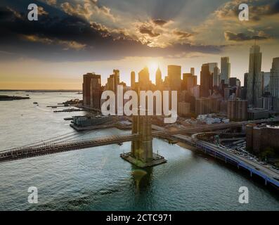 Brooklyn Bridge in der Abenddämmerung an der Skyline von Lower Manhattan am East River in New York, New York, USA Stockfoto