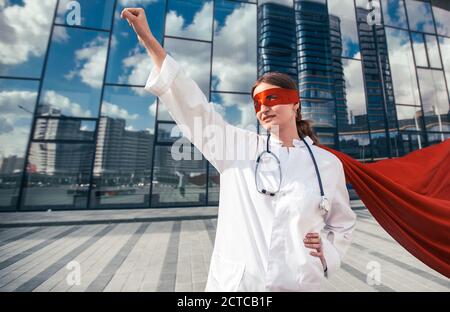 Ärztin in einem Superhelden Cape ist bereit zu helfen. Stockfoto