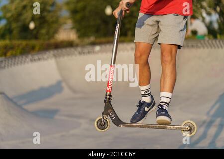 Moskau, Russland - 11. September 2020: Teenager führt einen Trick in der Stadt Skatepark. Roller schieben. Er springt über ein Hindernis. Extremsport Stockfoto