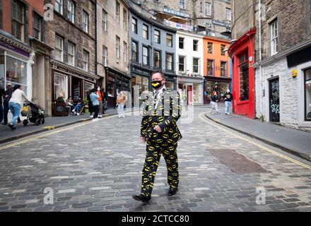 Ein Mann mit Batman-Anzug und Gesichtsmaske geht die Victoria Street in Edinburgh entlang, nachdem der erste Minister Nicola Sturgeon eine Reihe neuer Maßnahmen angekündigt hatte, um den Anstieg der Coronavirus-Fälle in Schottland zu bekämpfen. Stockfoto