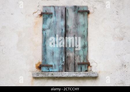 Altes Fenster mit blauem Verschluss aus Holz. Stockfoto