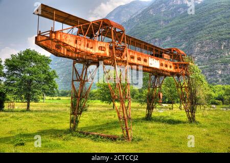 Rostiger Gantry Kran auf dem Grünen Feld mit Berg in der Schweiz. Stockfoto